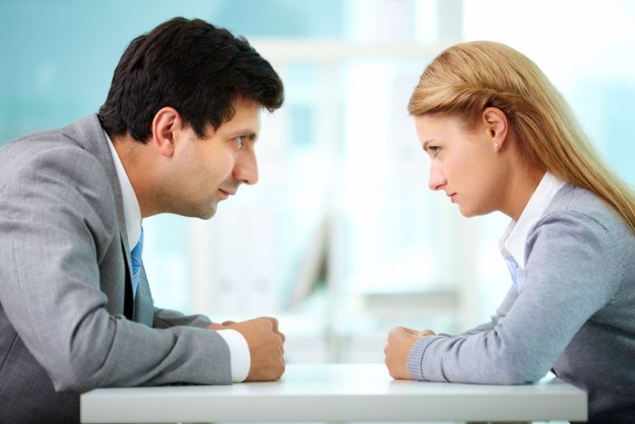 Profiles of serious employees looking at each other
