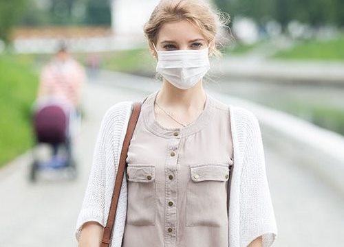 Portrait of sick woman wearing protective mask against infective diseases