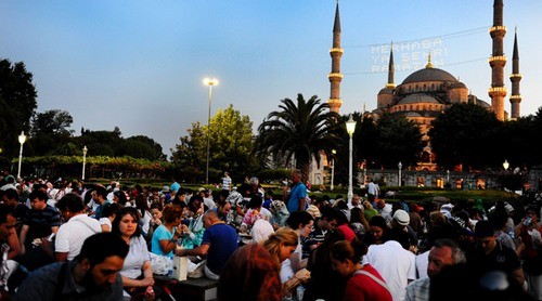 istanbul'da ramazan nedeniyle vatandaslar sultanahmet camii ve meydanina akin ediyorlar. meydanda kurulan standlarda ve tezgahlarda alis veris yapan vatandaslar iftar vaktini bekliyorlar. mahya (zaman/ selman esturkler)
